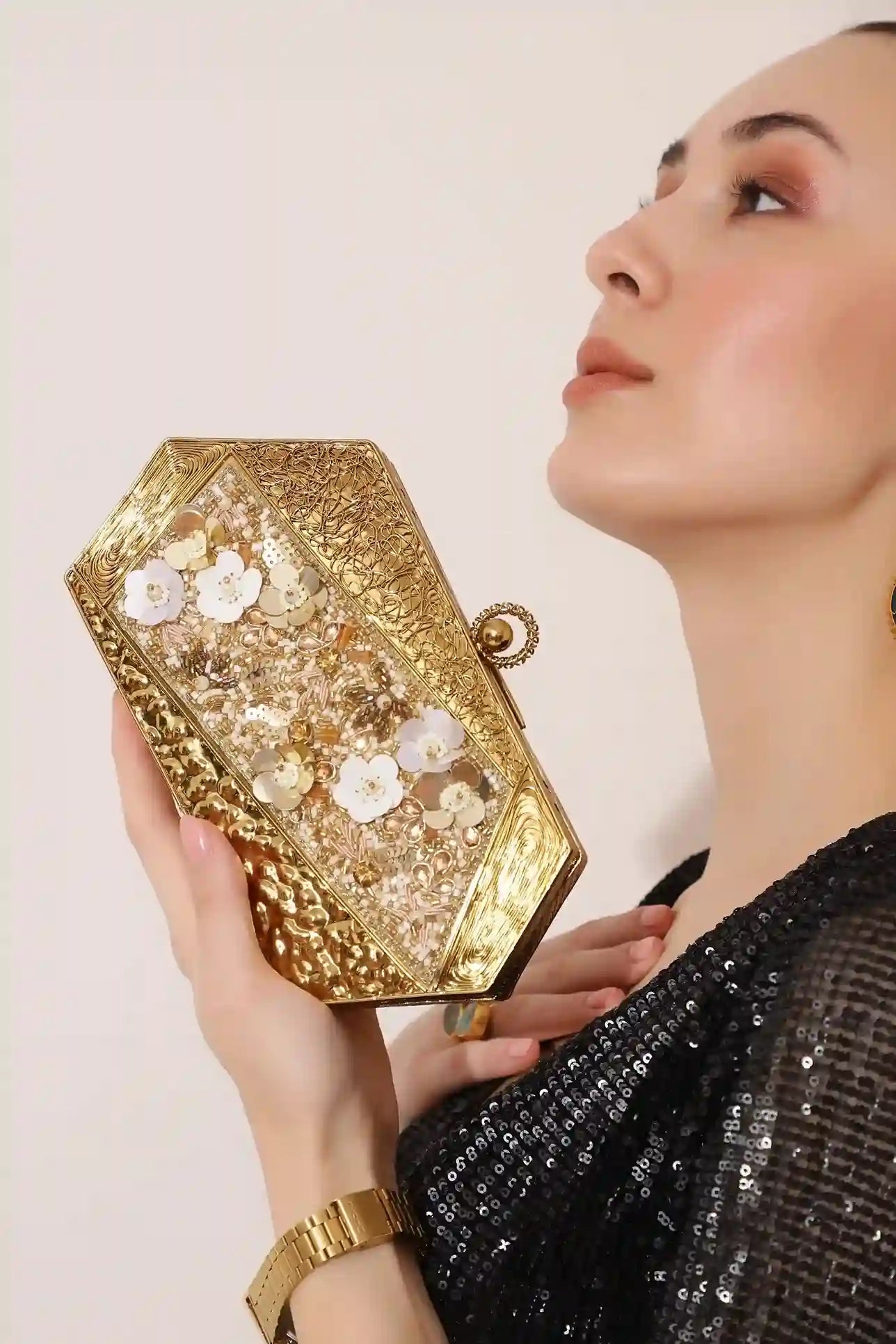 Gold brass clutch with intricate embellishments and detailed design, featuring the Fatima motif for elegant evening wear.