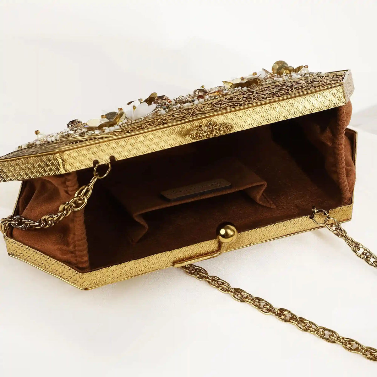 Gold brass clutch with intricate embellishments by The Tan Clan, featuring a sleek, elegant design perfect for evening occasions.