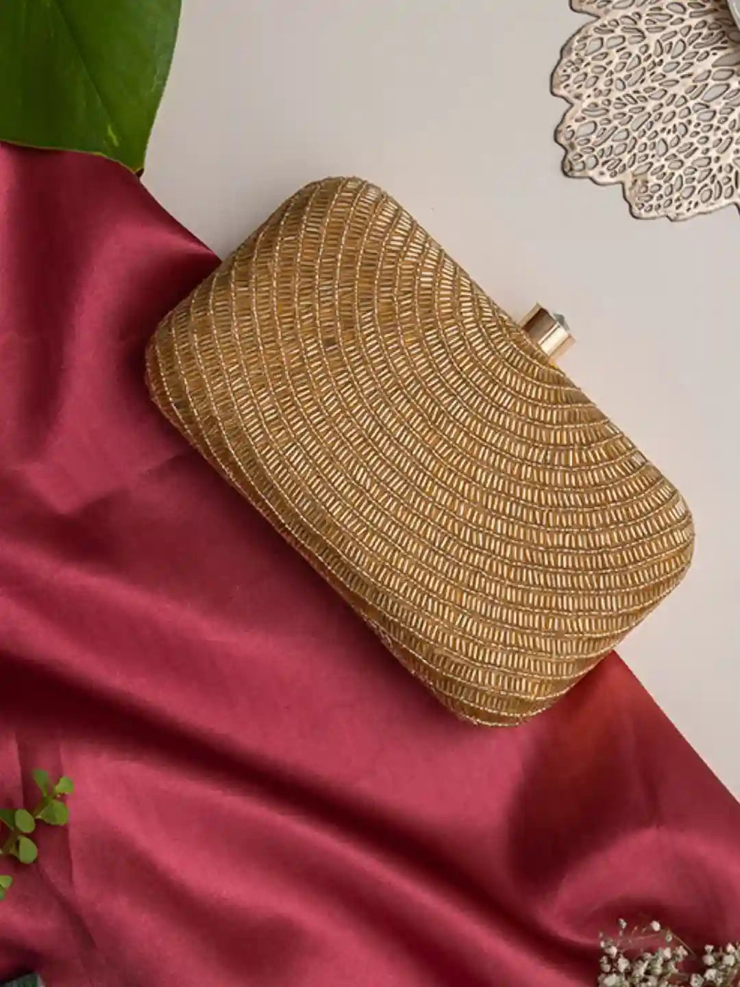 Golden hand-embroidered party clutch by The Tan Clan featuring glittering accents and elegant design for special occasions.
