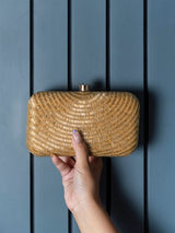 Golden hand-embroidered party clutch by The Tan Clan featuring intricate gold embroidery on a stylish evening bag.