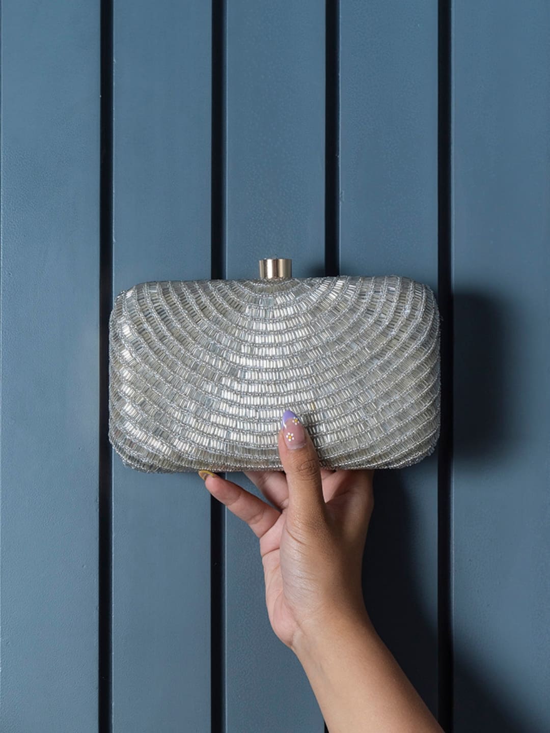 Silver hand-embroidered party clutch by The Tan Clan with intricate glittering design and compact, elegant shape.