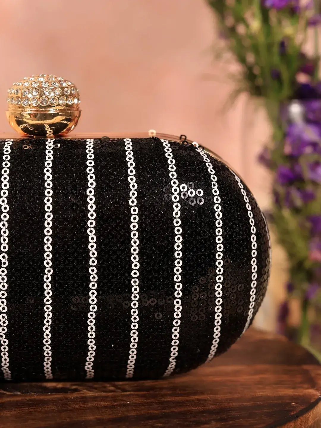 Black sequins oval clutch by The Tan Clan featuring a shimmering glow design, ideal for elegant evening occasions.