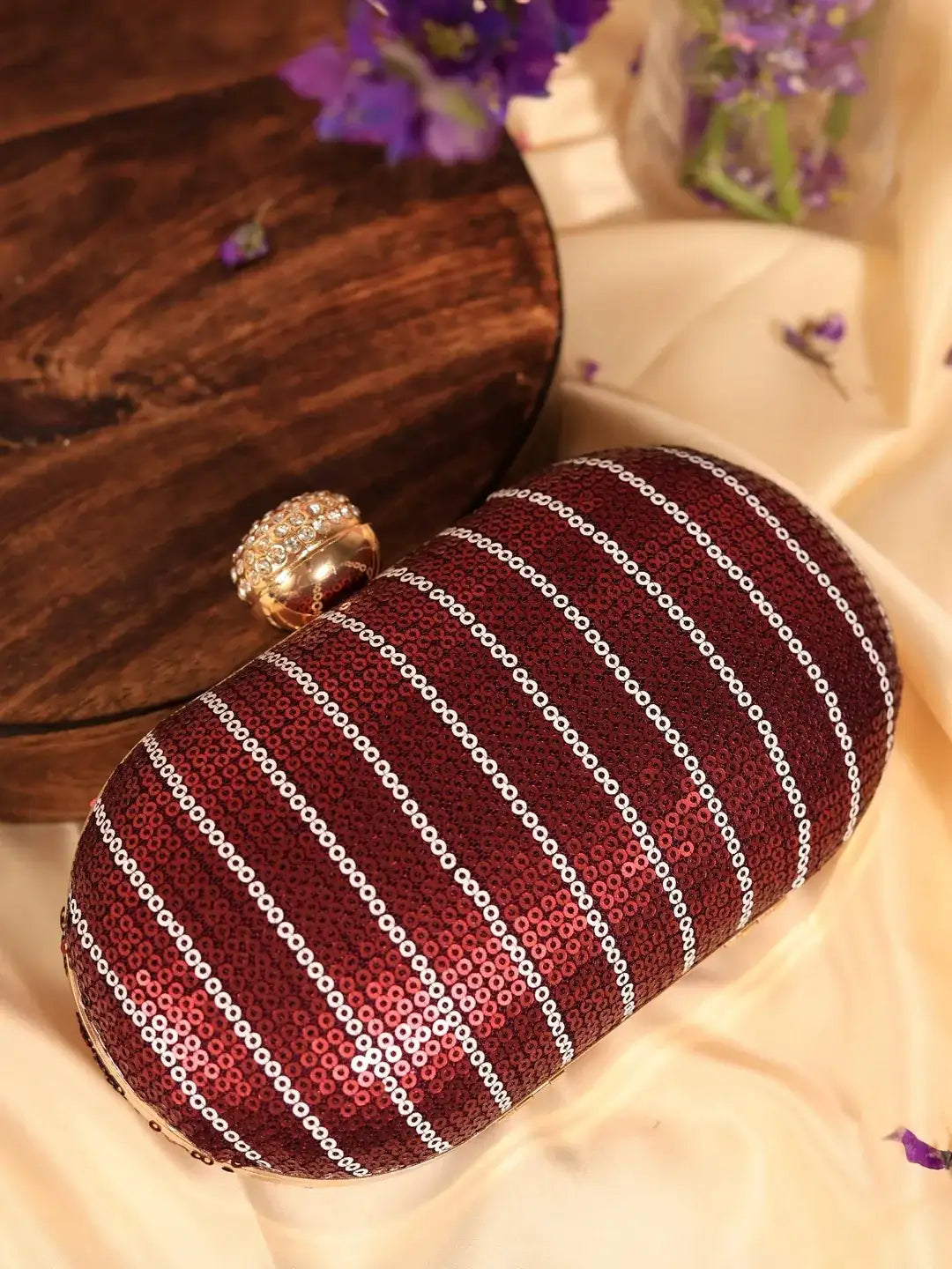 Maroon sequins glow oval clutch bag by The Tan Clan, featuring sparkling embellishments and a sleek, elegant design.