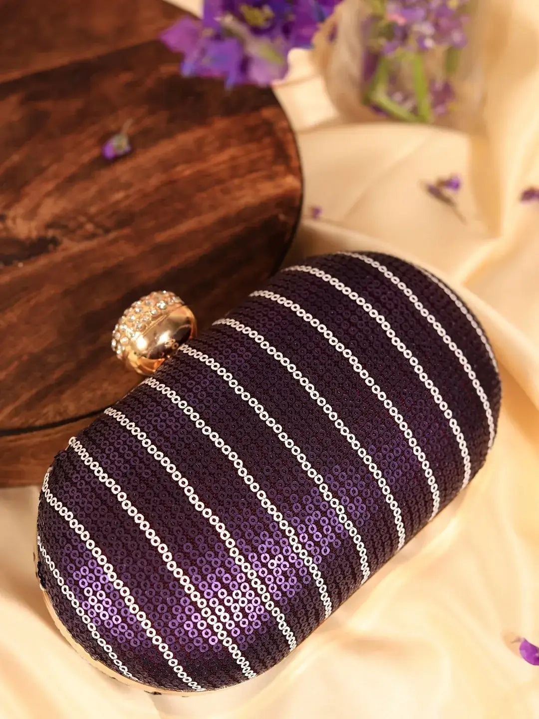 Purple sequins oval clutch bag by The Tan Clan, featuring a shimmering glow for elegant occasions.