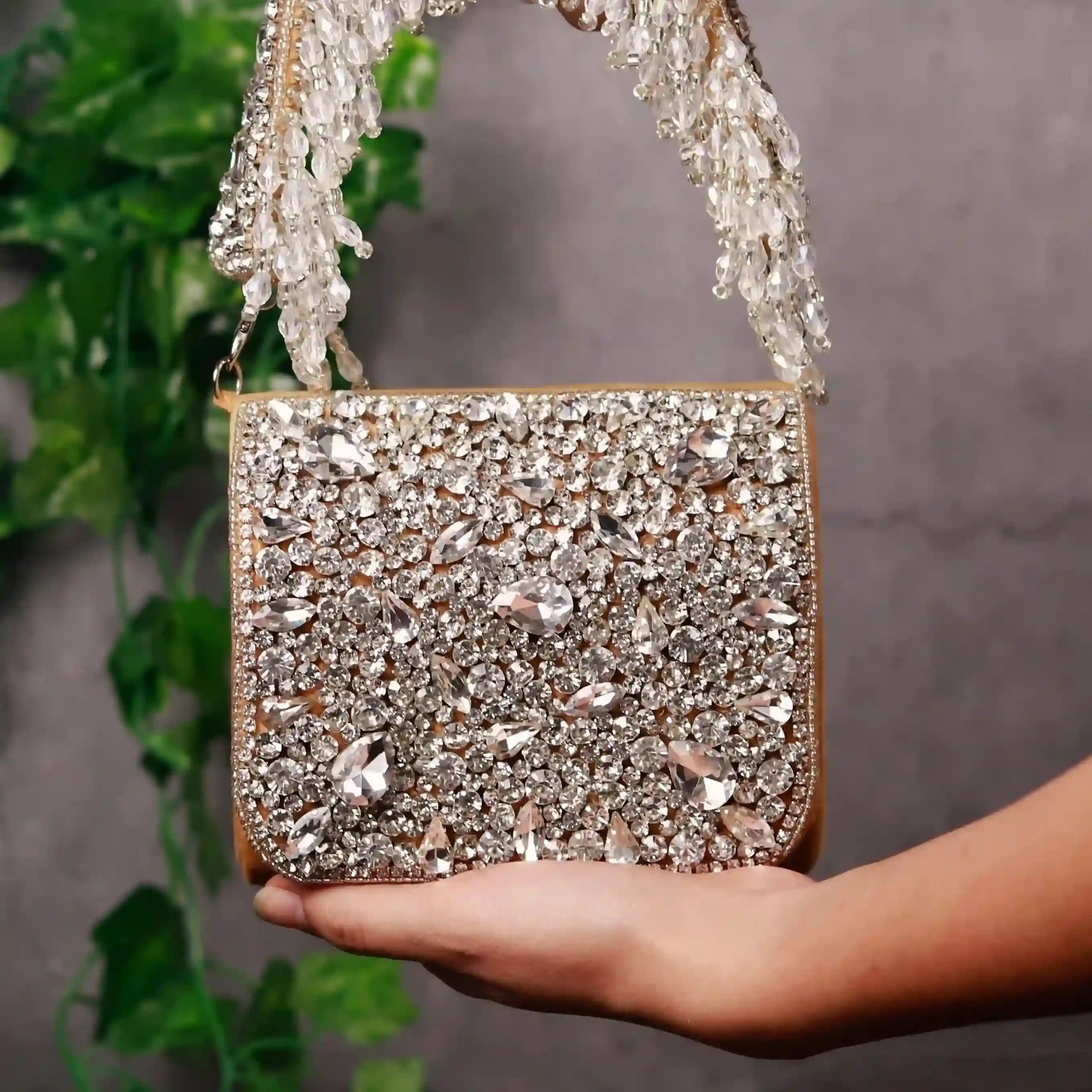 Gold mini bag with embroidered handle by The Tan Clan featuring a sleek design and detailed embroidery on the handle.