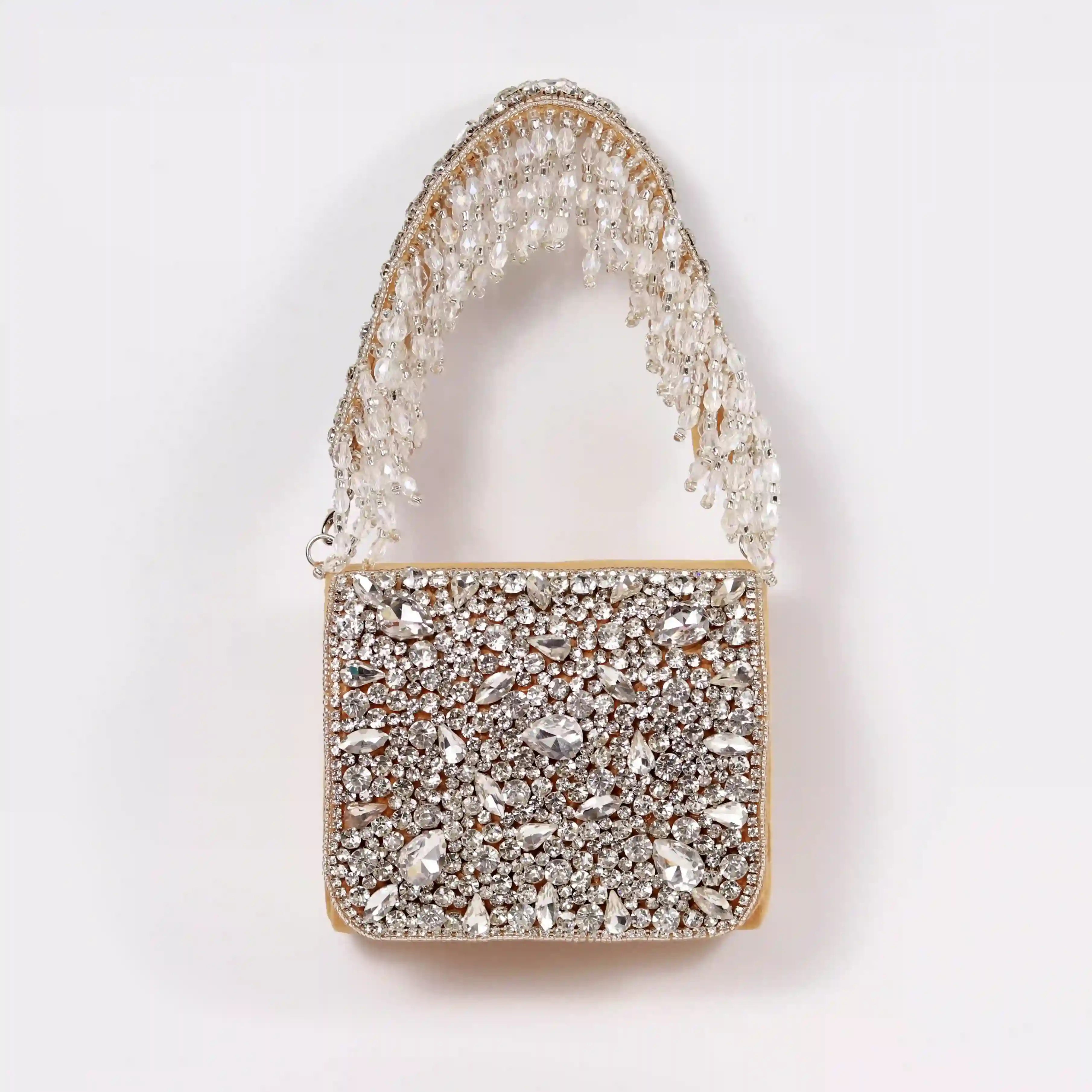 Gold mini bag from The Tan Clan with an embroidered handle, featuring a sleek design and compact size.
