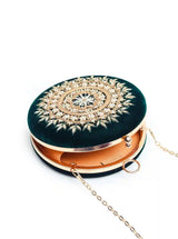 Green round clutch bag with intricate hand embroidery by The Tan Clan, featuring detailed craftsmanship and vibrant design.