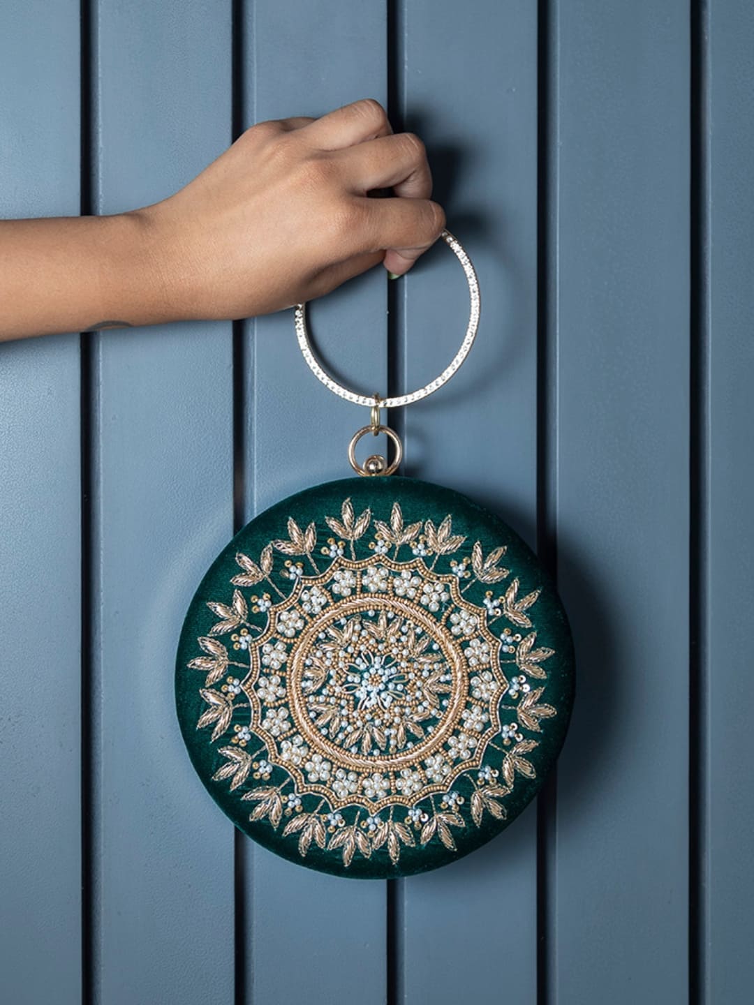 Green round clutch by The Tan Clan with intricate hand embroidery, featuring a compact and stylish design for elegant occasions.
