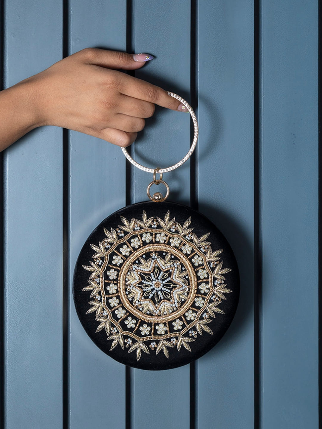 Round hand-embroidered clutch bag featuring intricate embroidery and a soft fabric exterior by The Tan Clan.