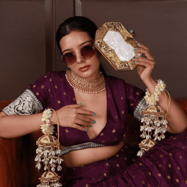Elegant Inaayat brass clutch with mother of pearl inlay, featuring a sleek design and intricate craftsmanship by The Tan Clan.