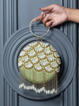 Round hand-embroidered clutch with tassels by The Tan Clan, featuring intricate embroidery and a stylish design.