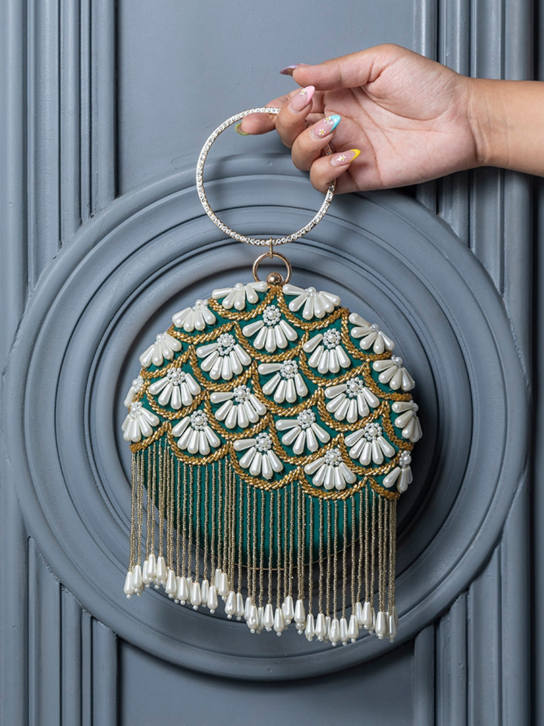 Dark green Irsa round hand-embroidered clutch with tassels by The Tan Clan, showcasing intricate embroidery and elegant design.