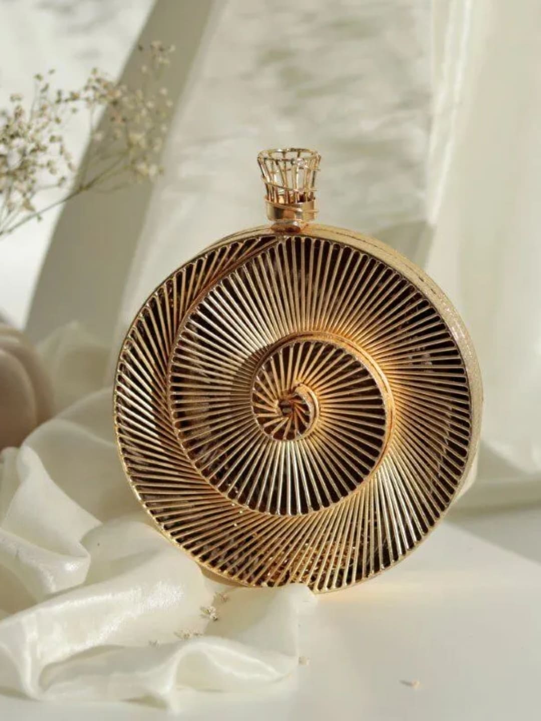 Intricate brass wirework clutch bag by The Tan Clan featuring detailed craftsmanship and elegant design.