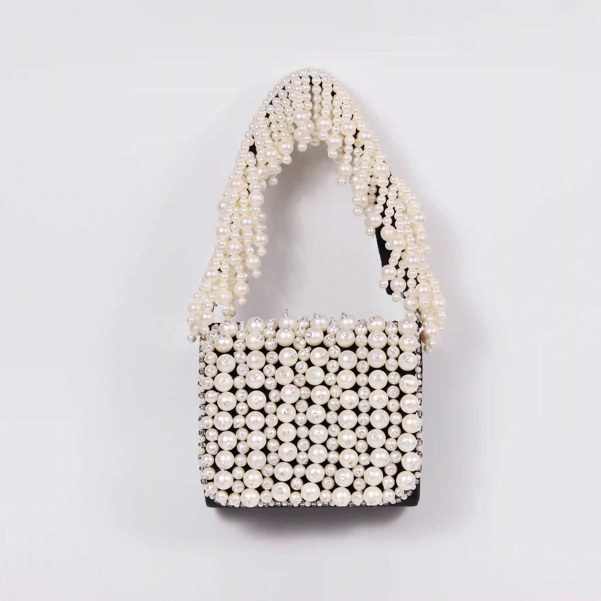 Jade mini bag by The Tan Clan featuring an embroidered handle and sleek design, perfect for stylish accessories.