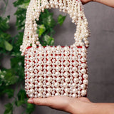 Jade mini bag from The Tan Clan with embroidered handle, featuring a compact design and detailed embroidery on the strap.