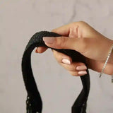 Black tassel potli bag with handle by The Tan Clan, featuring intricate embroidery and traditional design.