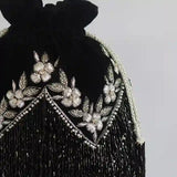 Black tassel potli bag with handle from The Tan Clan, featuring intricate design and traditional Indian craftsmanship.