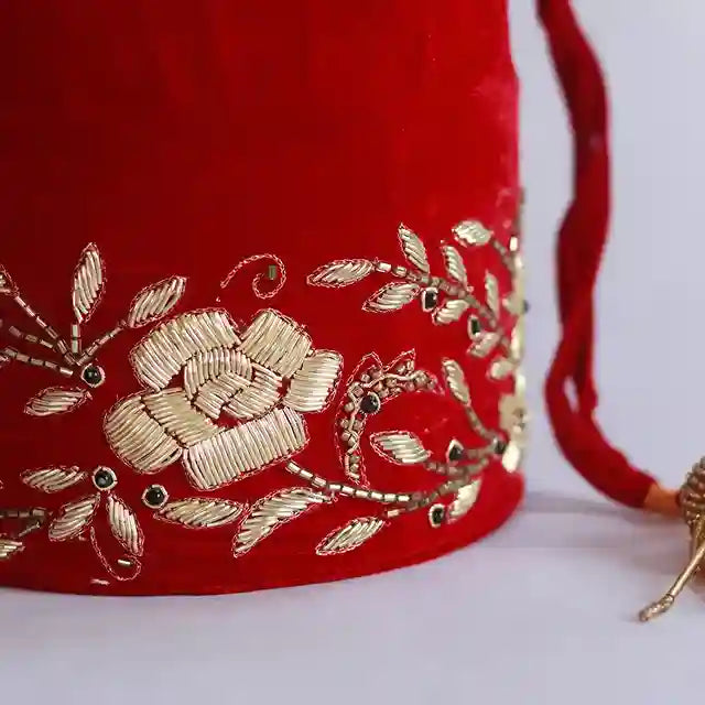 Red bridal Zardozi embroidered potli bag with intricate gold threadwork and traditional embellishments, handcrafted by The Tan Clan.