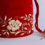 Red bridal Zardozi embroidered potli bag with intricate gold threadwork and traditional embellishments, handcrafted by The Tan Clan.
