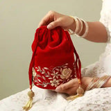Red bridal Zardozi embroidered potli bag with intricate gold embroidery, traditional Indian accessory for festive and wedding wear.