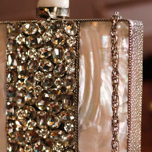 Liyana Mother of Pearl Clutch by The Tan Clan featuring a shimmering pearl finish and elegant rectangular design.