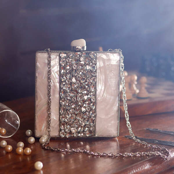 Liyana Mother of Pearl Clutch by The Tan Clan, showcasing a shimmering iridescent pearl finish and elegant compact design.