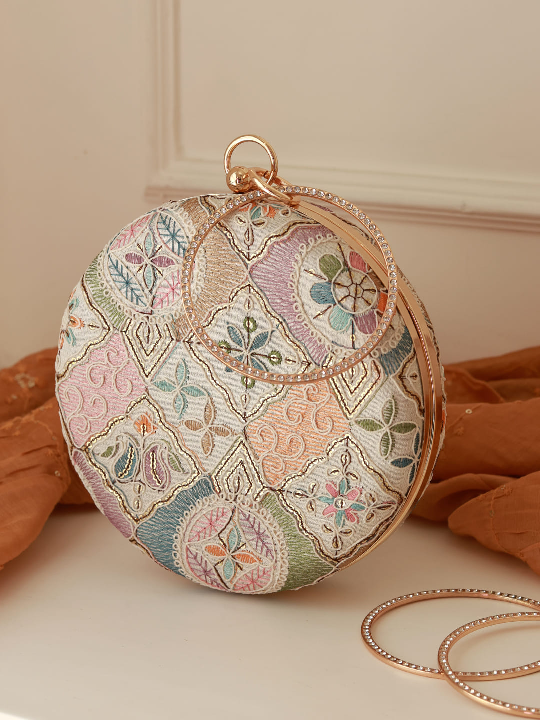 Mughal round clutch bag by The Tan Clan featuring intricate traditional patterns and a round shape.