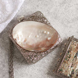 Mumtaz mother of pearl clutch by The Tan Clan featuring a shimmering pearl design and elegant compact shape.