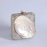 Mother of pearl clutch bag by The Tan Clan featuring a sleek, elegant design with a shimmering pearl finish.