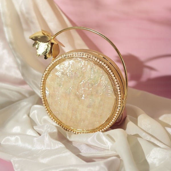 Naaz embellished mother of pearl clutch with intricate detailing, featuring a sleek design and metallic accents from The Tan Clan.