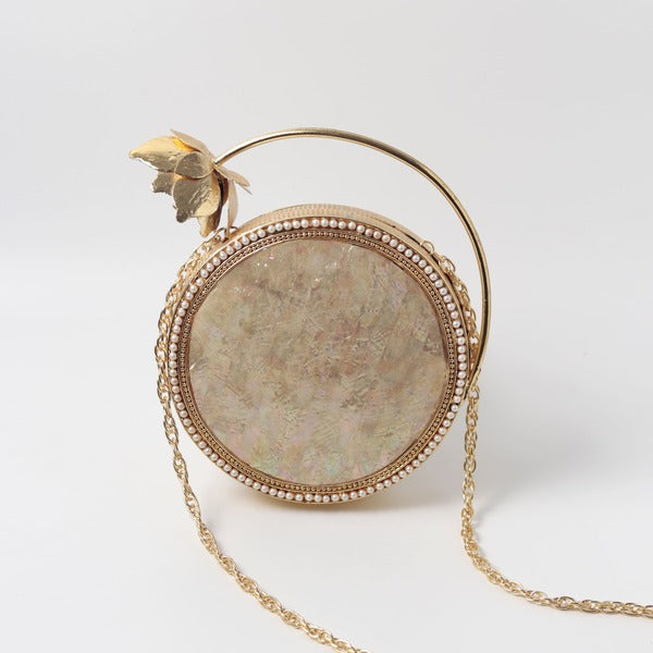 Naaz embellished mother of pearl clutch by The Tan Clan, featuring intricate design and shimmering pearl accents.