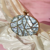 Nargis embellished mother of pearl clutch by The Tan Clan featuring intricate detailing and a sleek, elegant design.
