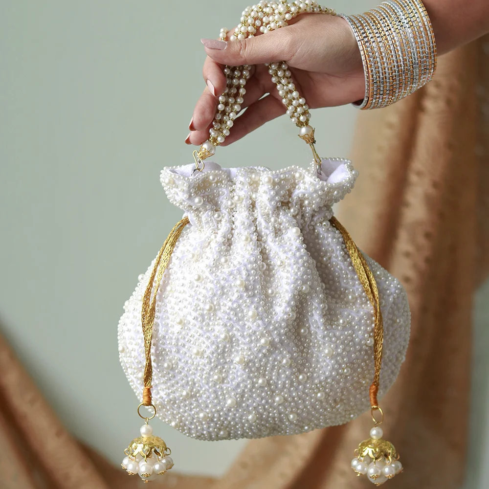 Elegant Nayaab Pearl Potli Bag with handle by The Tan Clan, featuring intricate pearl embellishments and traditional Indian design.