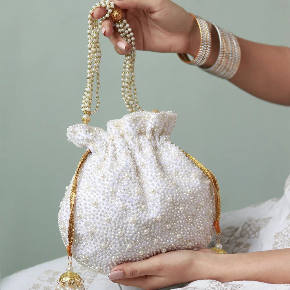 Elegant pearl potli bag with handle by The Tan Clan, featuring intricate pearl embroidery and traditional Indian craftsmanship.