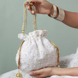 Elegant pearl potli bag with handle by The Tan Clan, featuring intricate pearl embroidery and traditional Indian craftsmanship.