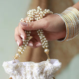 Elegant Nayaab Pearl Potli Bag with handle by The Tan Clan, featuring intricate pearl embroidery and a traditional design.