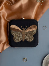 Black square clutch by The Tan Clan with hand-embroidered butterfly design, featuring intricate embroidery and elegant craftsmanship.