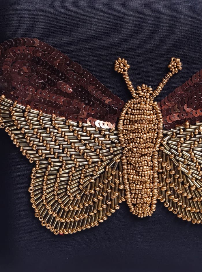 Black square clutch by The Tan Clan with hand-embroidered butterfly design, featuring intricate embroidery and elegant craftsmanship.