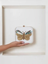 White square clutch bag with hand-embroidered butterfly design by The Tan Clan, stylish accessory for special occasions.