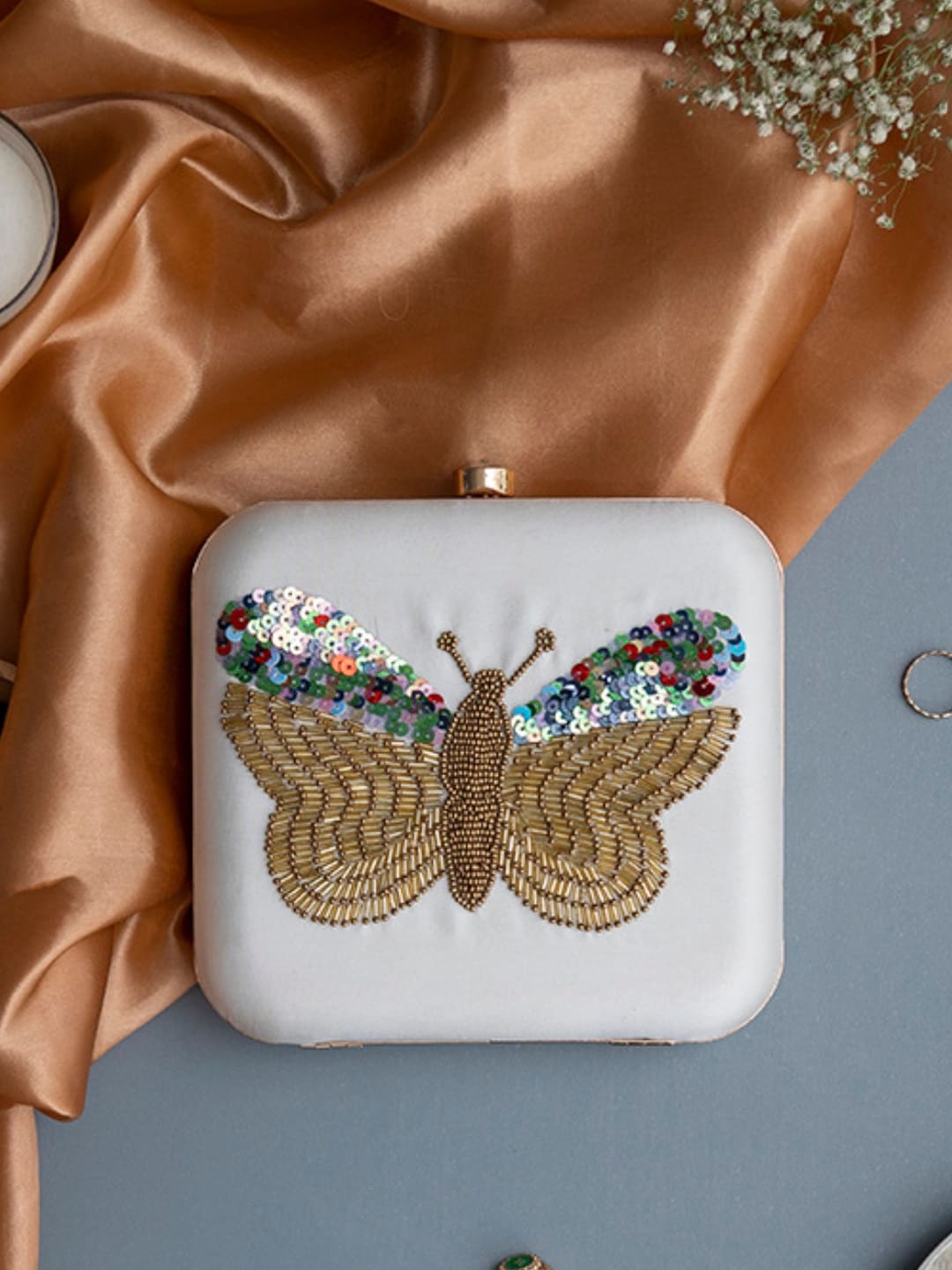 White square hand-embroidered butterfly clutch by The Tan Clan with intricate embroidery and elegant design.