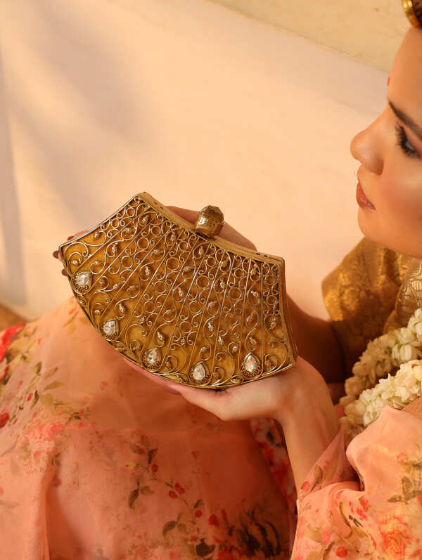 Intricate embellished brass clutch by The Tan Clan featuring detailed craftsmanship and elegant design.
