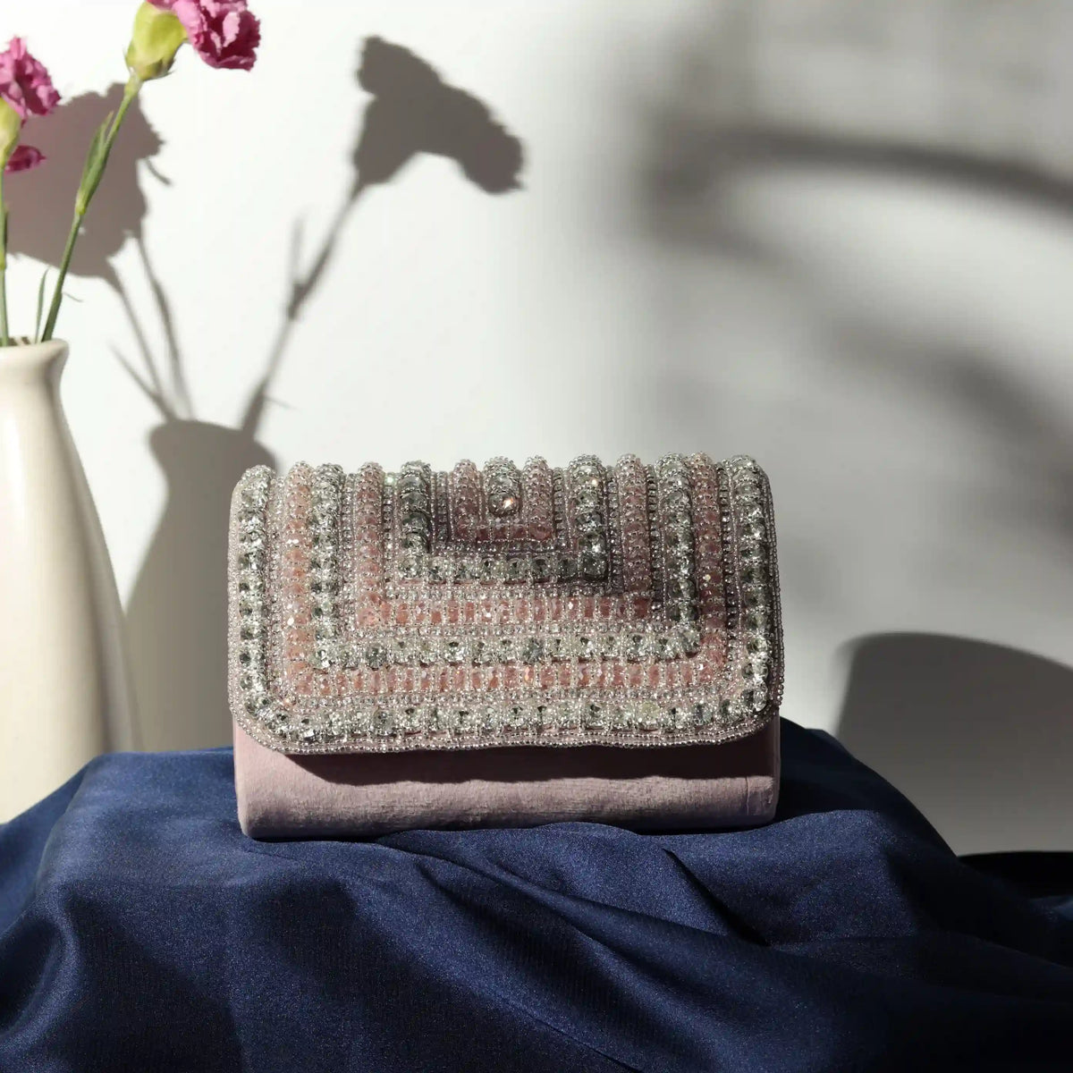 Nysa embellished flap-over clutch bag by The Tan Clan with decorative accents and a sleek design for elegant occasions.