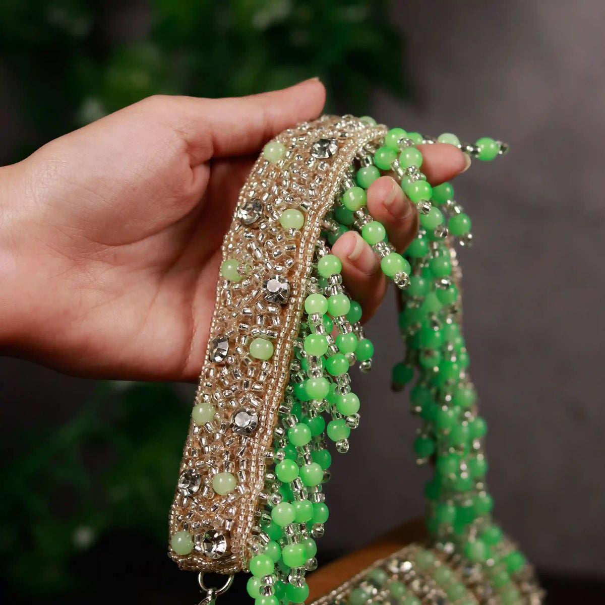 Green Nysa clutch bag with embellished flap over design by The Tan Clan, featuring a stylish and elegant accessory for evening occasions.