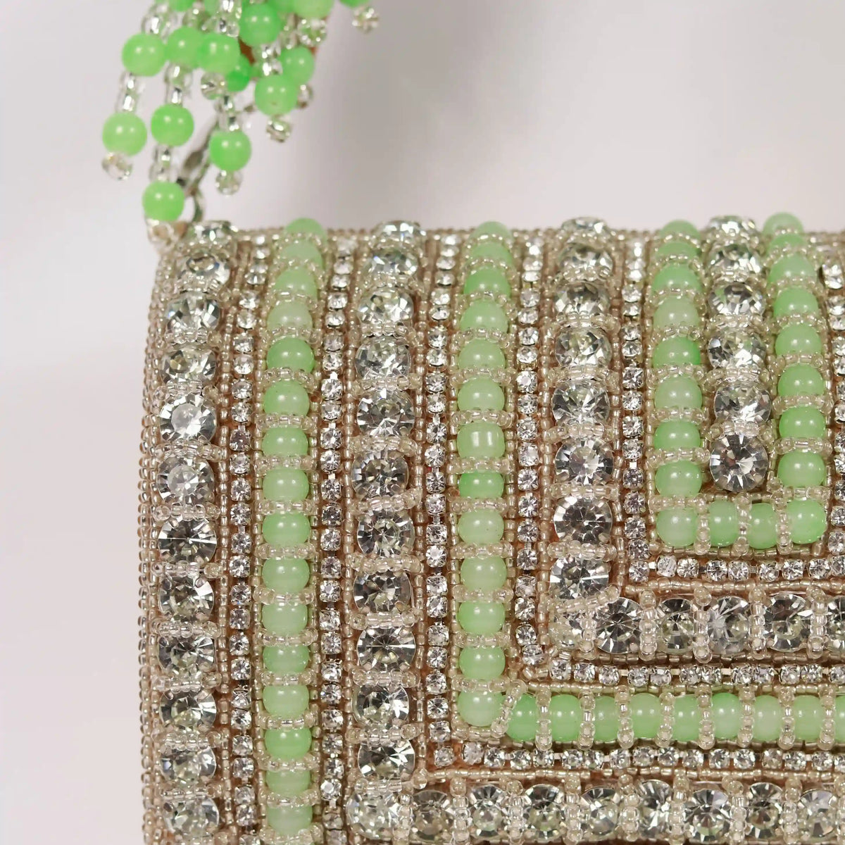 Nysa green embellished flap-over clutch bag by The Tan Clan, featuring intricate detailing and a sleek design.