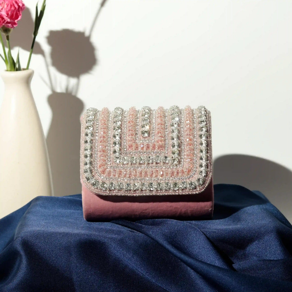 Pink Nysa mini bag with embroidered handle from The Tan Clan, featuring a compact design and detailed embroidery on the strap.
