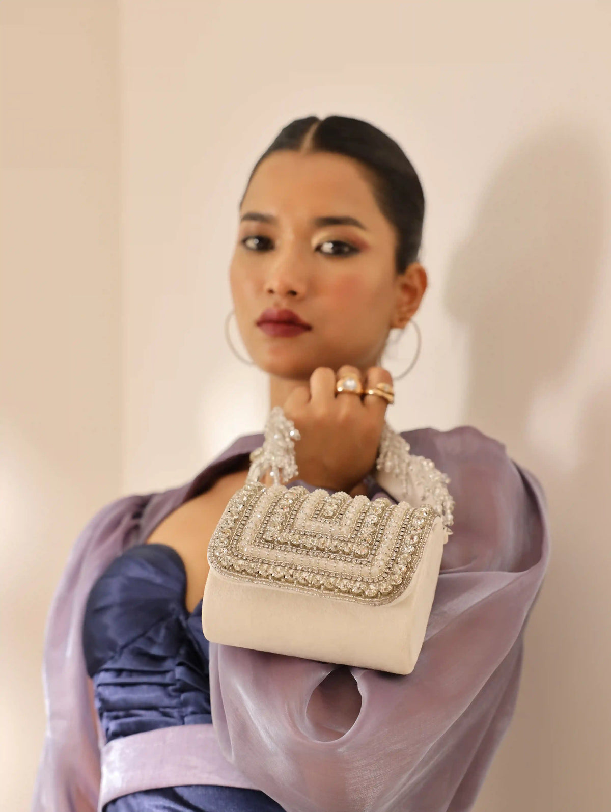 White Nysa mini bag by The Tan Clan with embroidered handle, featuring a compact design and stylish detailing.
