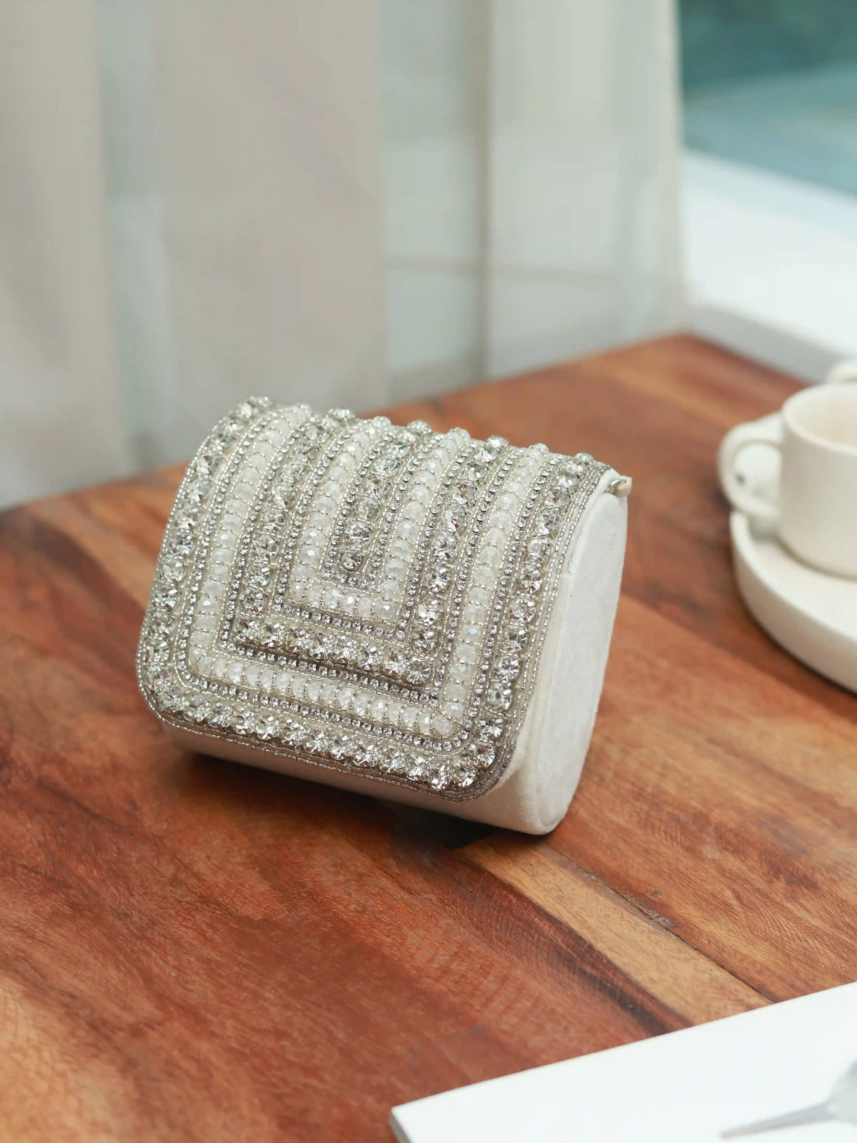 Nysa white mini bag with embroidered handle by The Tan Clan, featuring a compact design and detailed embroidery.