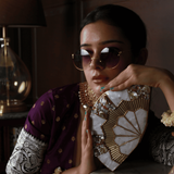 Golden brass mother of pearl clutch bag by The Tan Clan featuring intricate design and elegant, shiny surface.