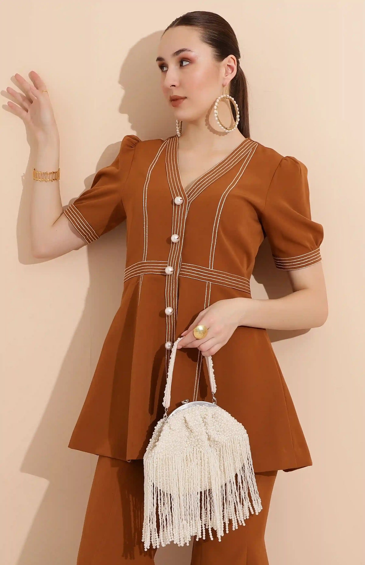 Pearl Batua bag with tassels from The Tan Clan, featuring a stylish design with pearl accents and decorative tassels.