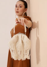 Pearl Batua bag with tassels from The Tan Clan, featuring a round shape, pearl embellishments, and decorative tassels.